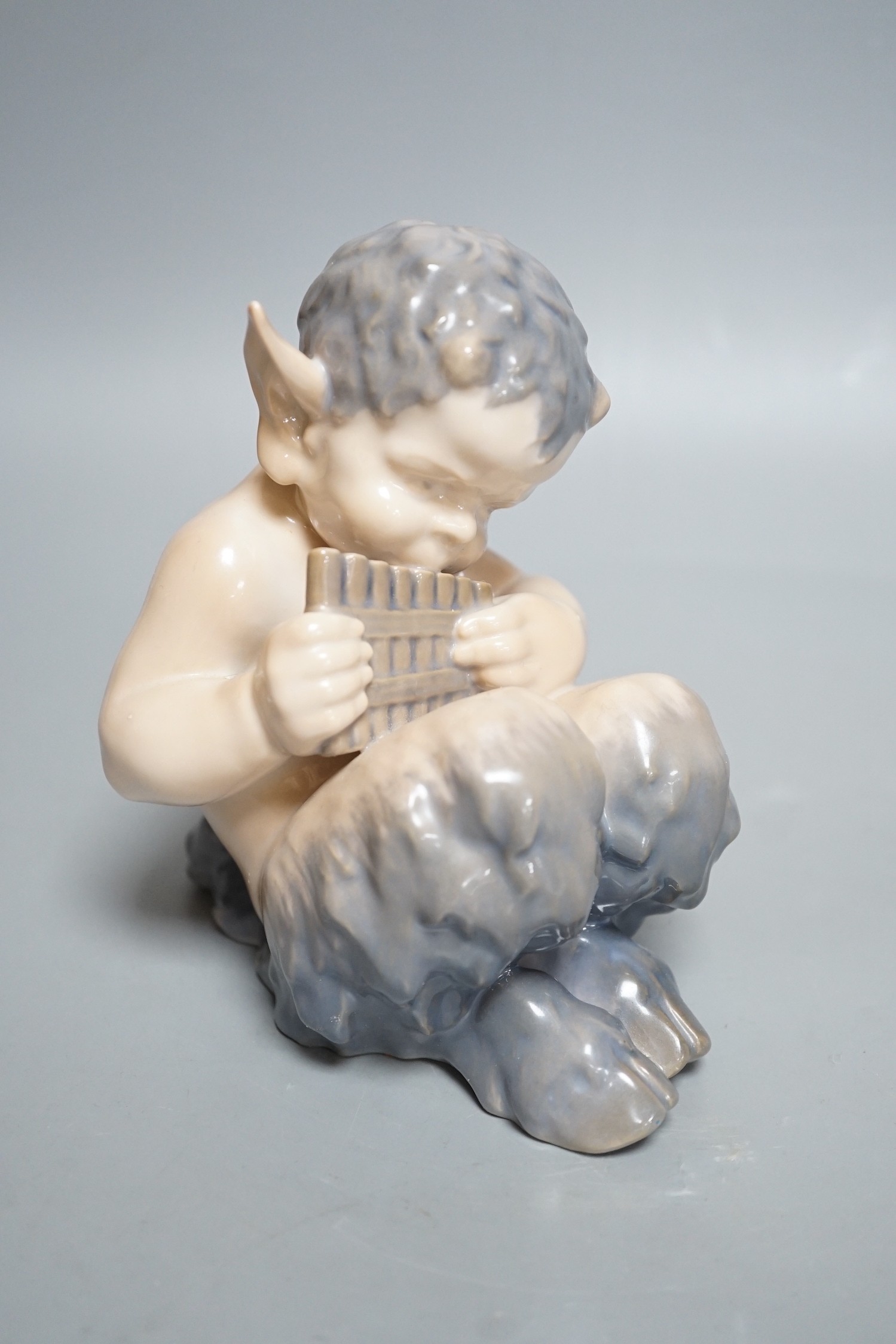 A Royal Copenhagen porcelain model of a seated faun, number 1736, 13cm tall